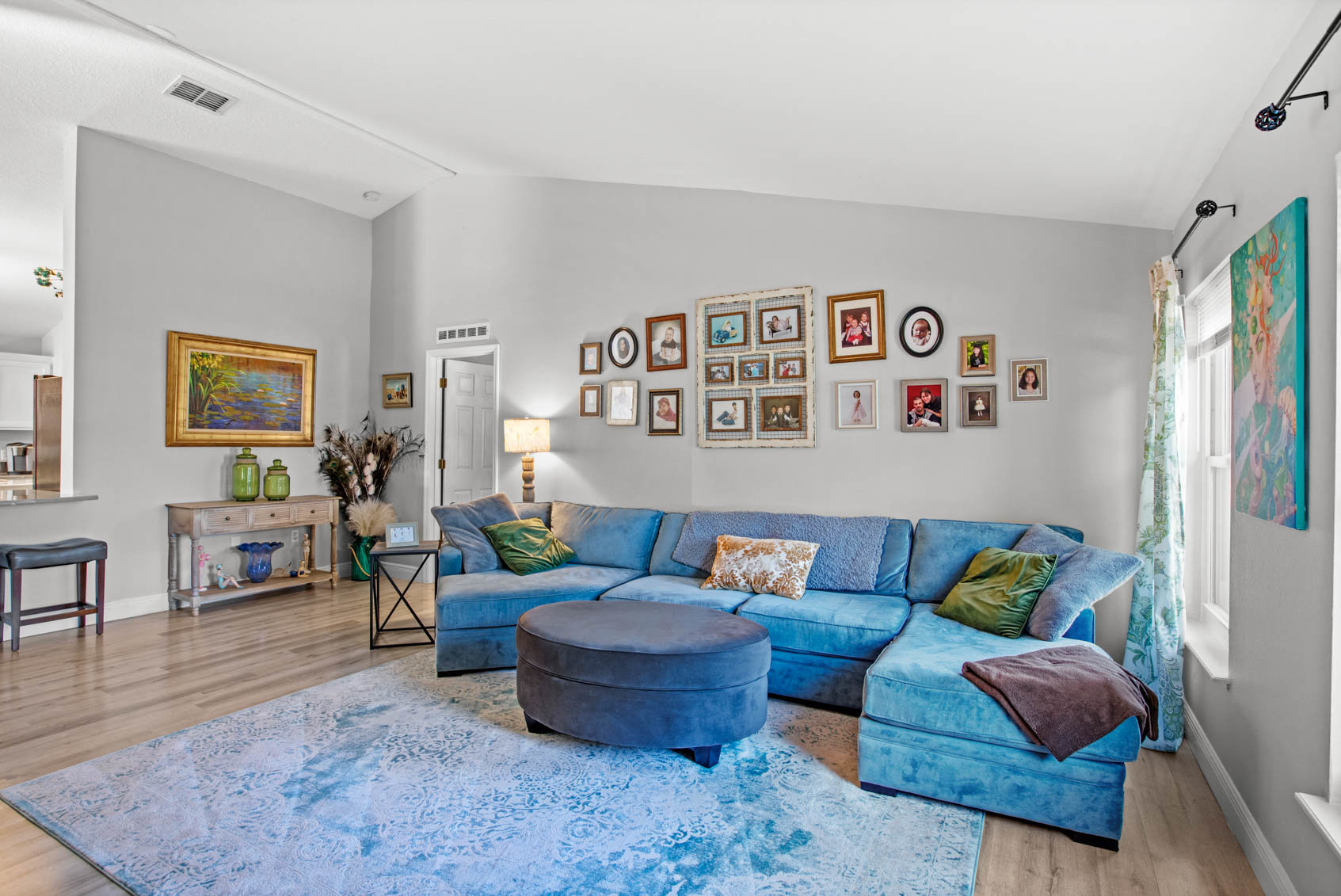 blue sectional with various frames on wall behind it